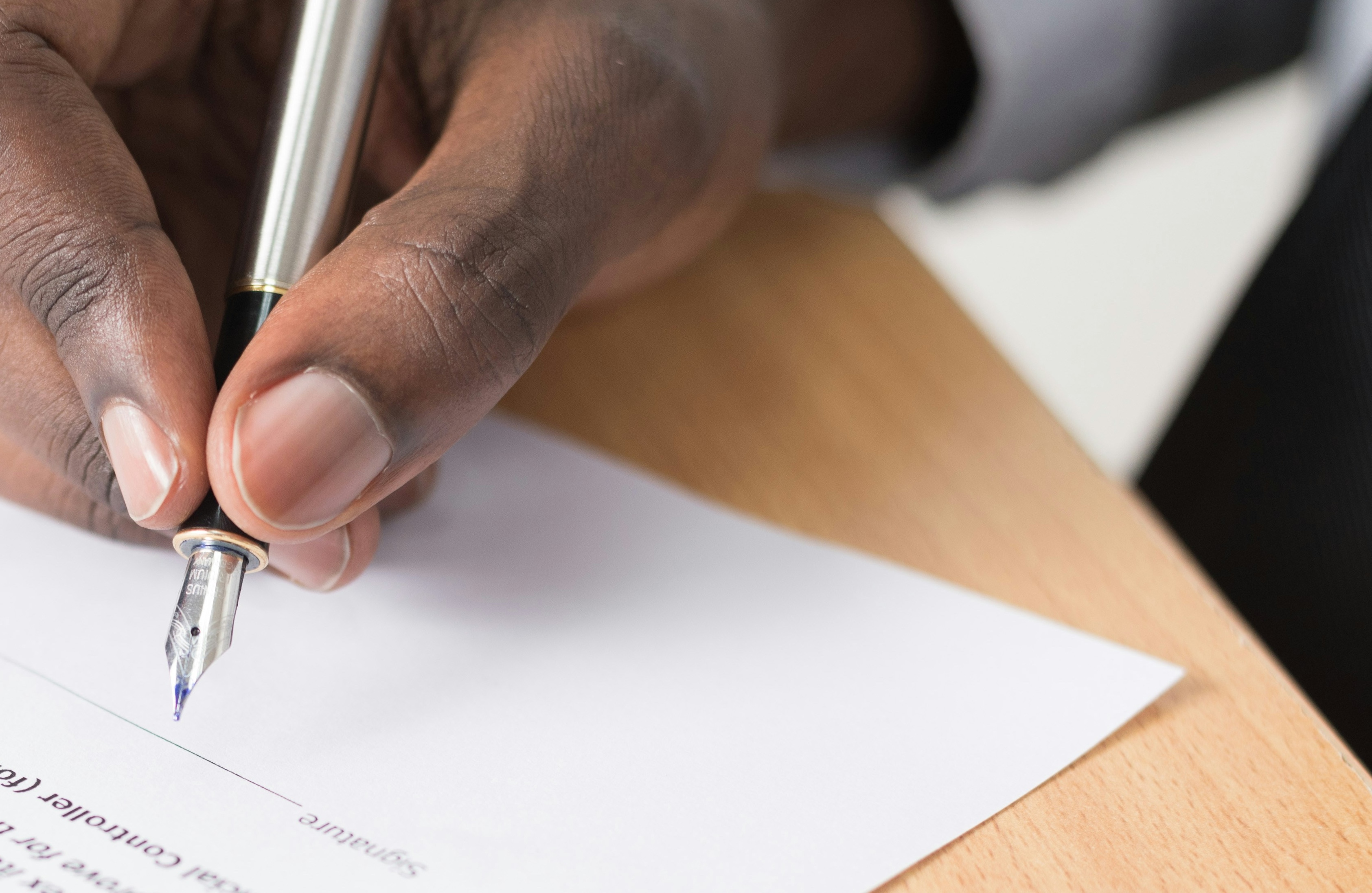 a hand signing a form